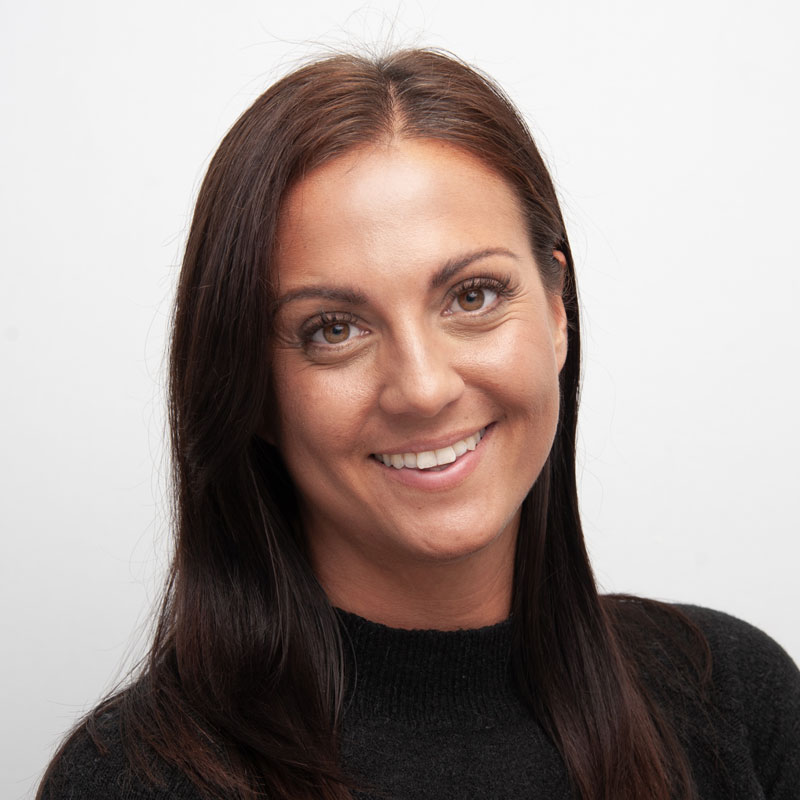 Image of a woman with olive skin, dark brown straight hair, light brown eyes wearing a black high neck jumper.