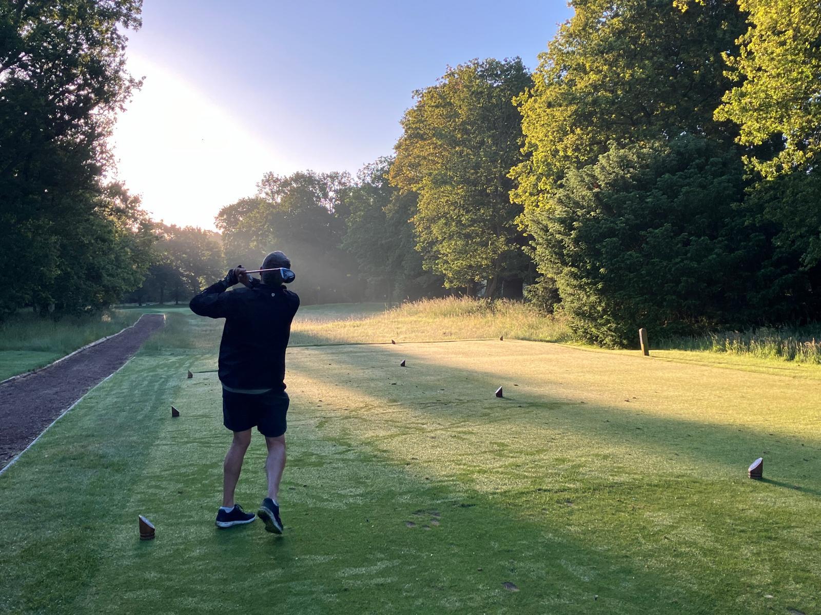 Image of a man playing golf as the sun rises at The Richmond Golf Club
