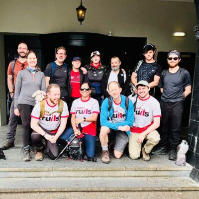 Group photo of the three peaks challenge team right before they start their challenge. they are wearing team Ruils t shirts and Their backpacks with their gear.