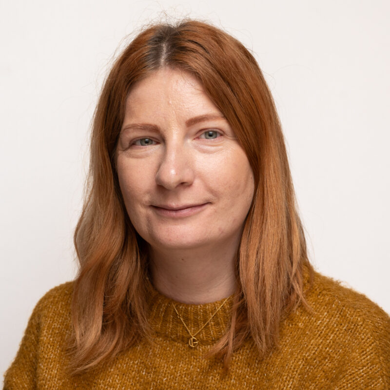 A woman with shoulder length hair and blue eyes