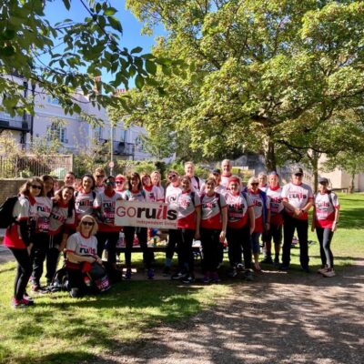 Group photo of about 25 people wearing team Ruils T shirts at the halfway point of the London virtual my way marathon. A group of people are holding the 