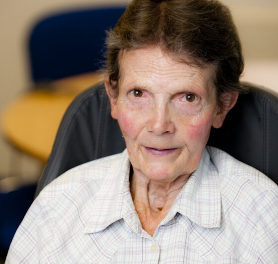 Image of founding member Jean Hamilton wearing a grey and blue plaid shirt.