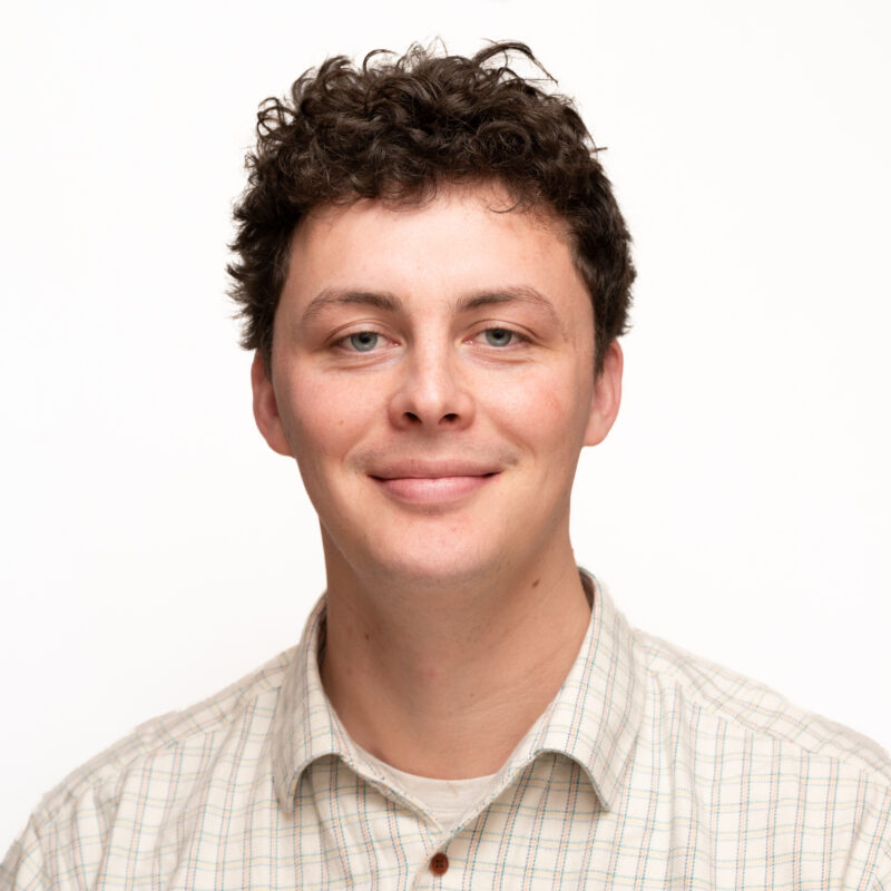 Man with short dark hair and blue eyes.