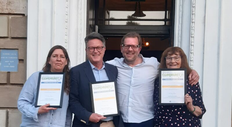 Image of three Ruils volunteers standing with our volunteer manager outside of an office building holding up their shortlisted awards.