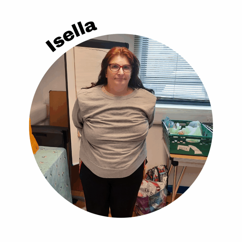 Image of Isella in a meeting room standing in front of a flip chart. She is wearing a grey shirt. Her name is above the photo in a circle frame.
