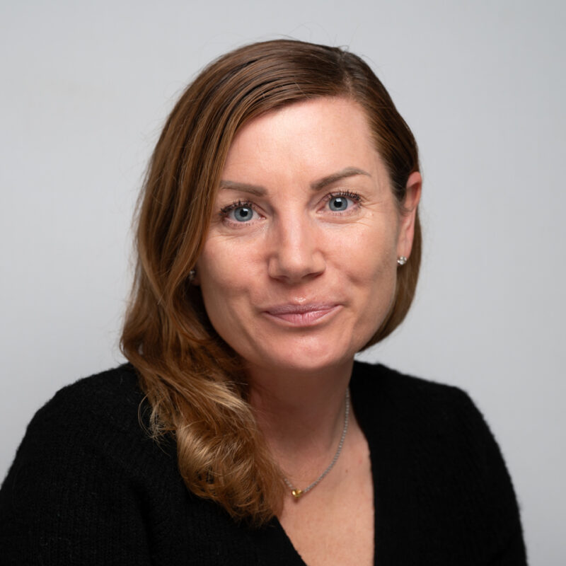 Woman with mid length brown hair and blue eyes