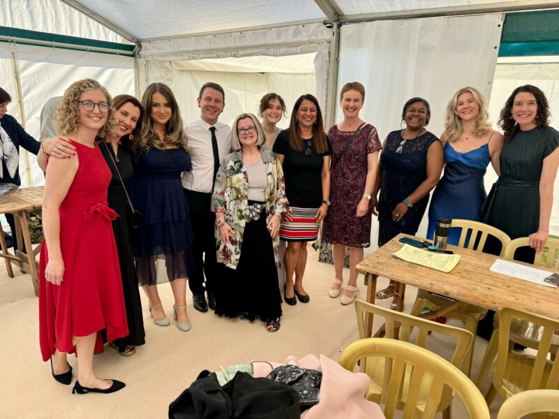 image of a group of people standing in a waiting room wearing nice formal clothing